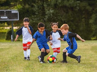 Kids Playing Outdoors to keep active and engaged, football is a way to keep your kids active