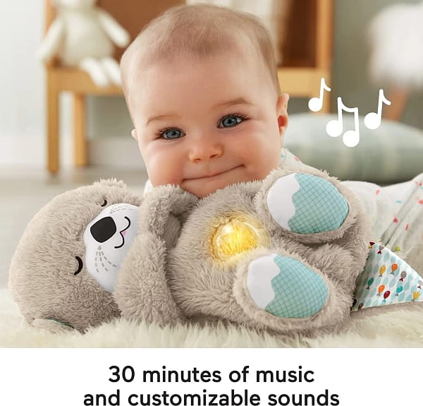 A baby playing with soft toy otter. Text reads: 30 minutes of music and customisable sounds.